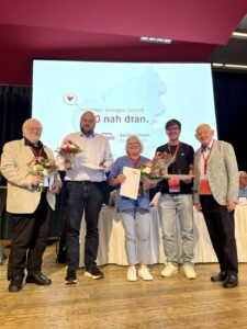 Gruppenbild der durch Rudi Frick geehrte Personen der Bezirkskonferenz. Von links nach rechts - Ullrich von Tollkacz, Tobias Zejewski, Maria Hilberg und Niklas Stelzer